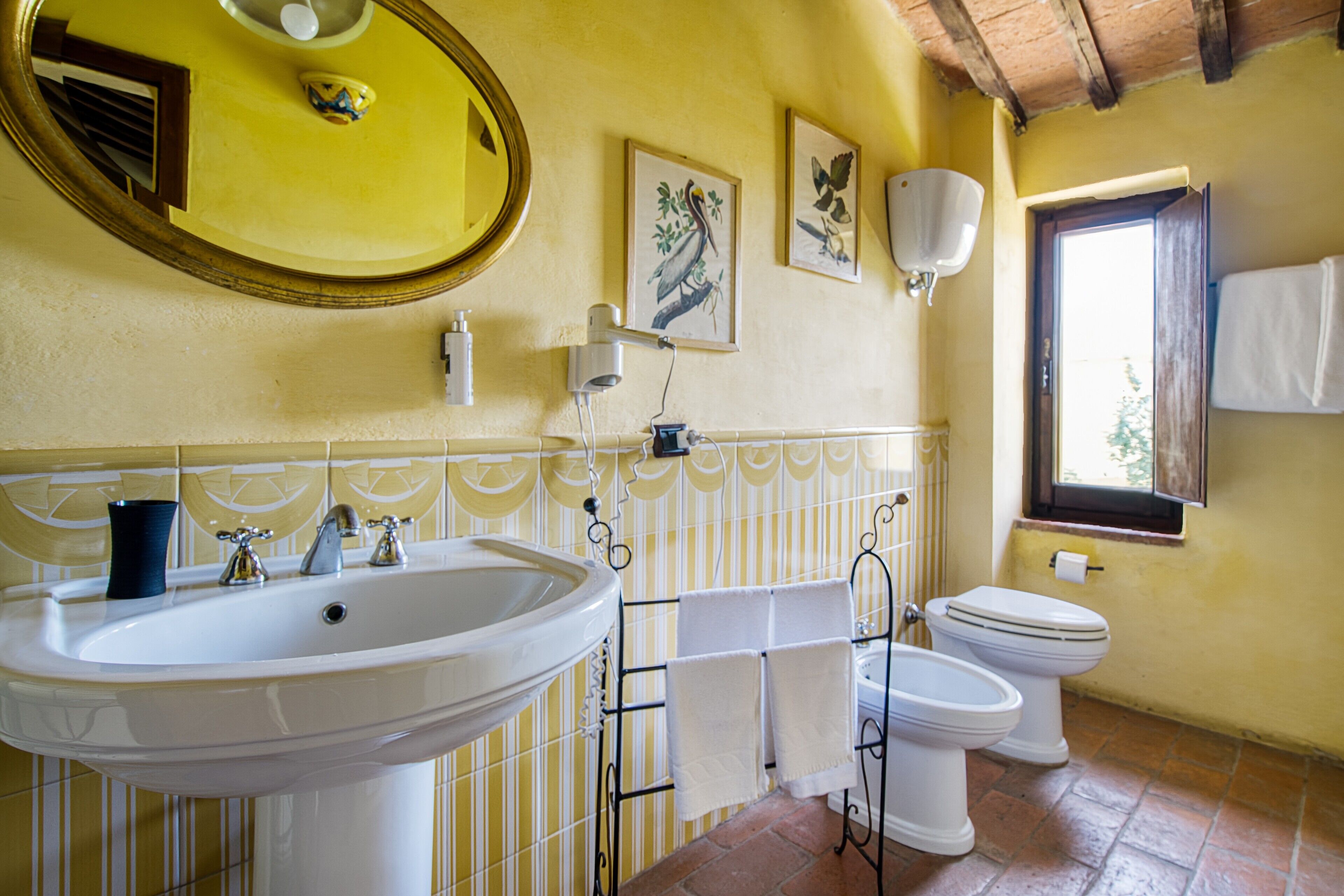 Un baño con lavamanos, inodoro y espejo.