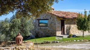 A stone house with a tiled roof, a small garden, and a clear sky. - Villa 'Le Buccole Country House' con vista sulle colline perugine, Wi-Fi e aria condizionata. (Marsciano)