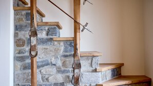 A stone staircase with wooden steps and metal handrails.