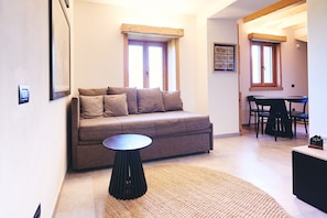 Un espace de vie comprenant un canapé, une table ronde et une table à manger avec des chaises.