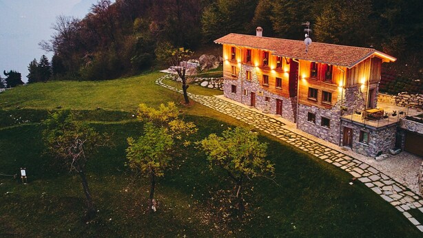 A stone house with a tiled roof, surrounded by a stone pathway and a grassy area. - Apartment in Luxury Chalet “Baita Treeb Breva” with Lake View & Wi-Fi - Civenna (Bellagio) (Bellagio)