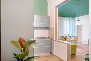 A modern kitchen with a gas stove, white cabinets, and a dining area with a table and chairs.