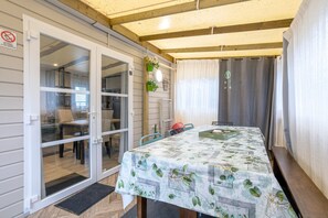 A room with a table, chairs, a door, and a window.