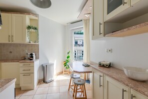 Una cocina con armarios, una encimera, un fregadero, una cafetera y una planta en maceta.