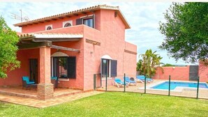 A two-story house with a swimming pool, outdoor seating, and a fenced patio area. - Villa 'Casa Fatima' with Sea View, Private Pool and Wi-Fi (El Palmar de Vejer)