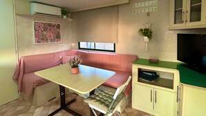 Une cuisine compacte avec une table à manger, un banc et un téléviseur.