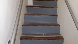 Un escalier avec des rampes en métal et des marches bleues.