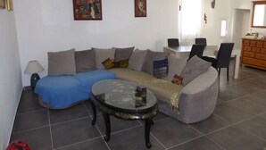Un salon comprenant un canapé, une table basse et un coin repas avec des chaises et une table.