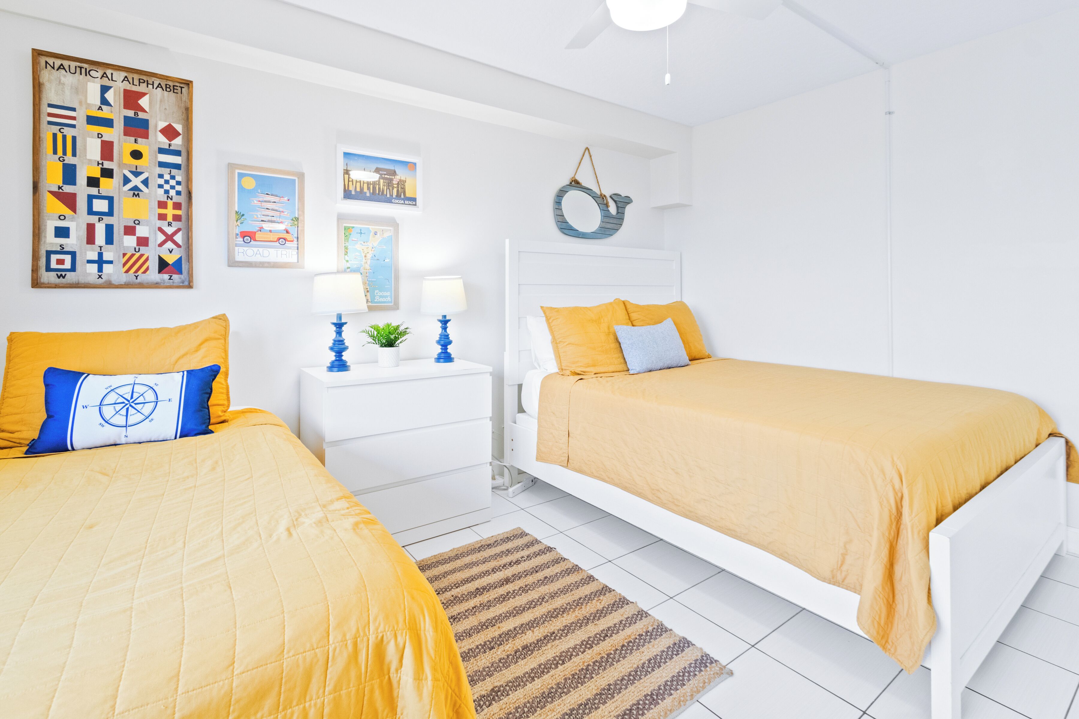 Ein Schlafzimmer mit zwei Betten, einem Wandbild im Seestil, einer Karte und einem Stadtbild.