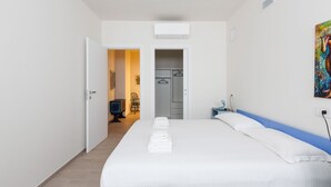 Een hotelkamer met een bed, een kledingkast, een bureau en een airconditioning.