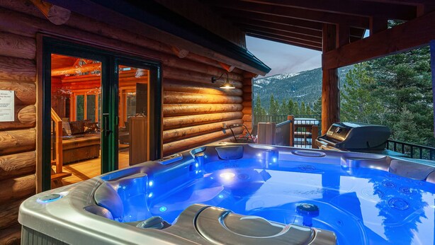 A wooden cabin with a hot tub and a glass door leading to a shower area. - Bridger Lodge: Ski-In Ski-Out/Hike/Bike/Fish/Hunt Bridger Bowl Ski Area (Bozeman)