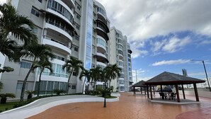 A modern building with multiple balconies and a covered outdoor seating area.