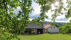 A house with a large lawn, a garage, and a white exterior wall.