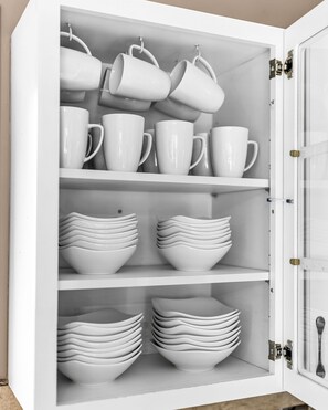 A white cabinet with multiple shelves holding white mugs and bowls. - Spacious light-filled house near Stillwater - The Stone's Throw Riverhouse (Stillwater)