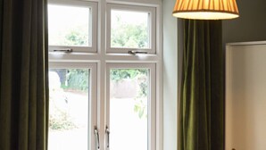 A room with a large window, a door, and a hanging lamp. - Emsworth`s Cosy Bungalow | Sleeps 3! (West Sussex)