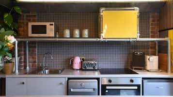 Geladeira, micro-ondas, cadeirão de bebê, cozinha com ilha