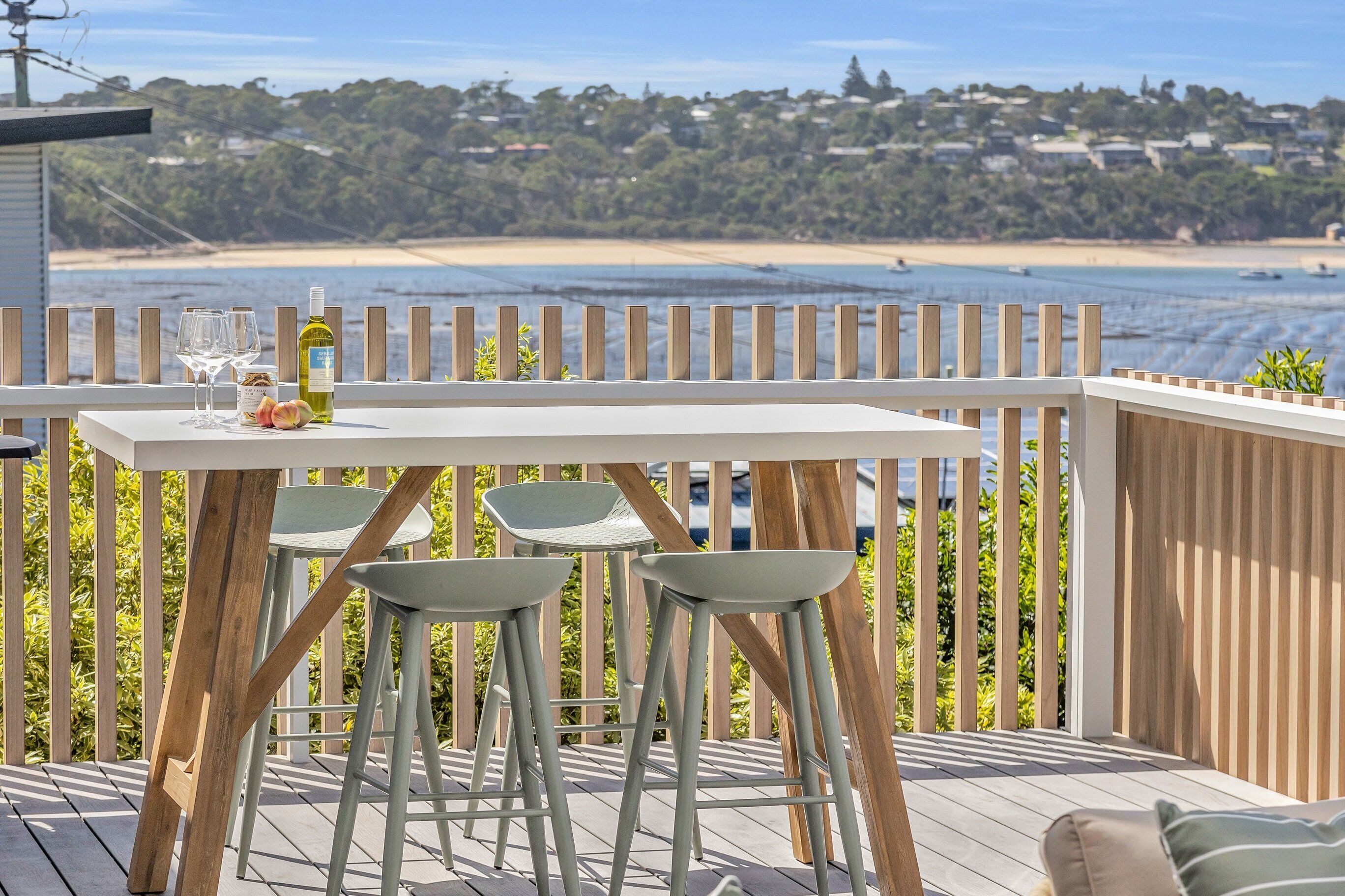 Una terrazza con tavolo e sgabelli vista spiaggia.