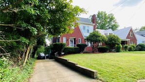 Una calle residencial con casas, aceras y una zona ajardinada.
