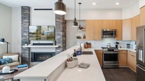 A modern kitchen with a central island, built-in oven, microwave, and stainless steel appliances.