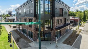 A modern two-story building with large windows and a stone facade at Cedar Street intersection.