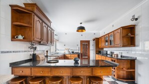 Una cocina moderna con armarios de madera, encimera negra y piso a cuadros.