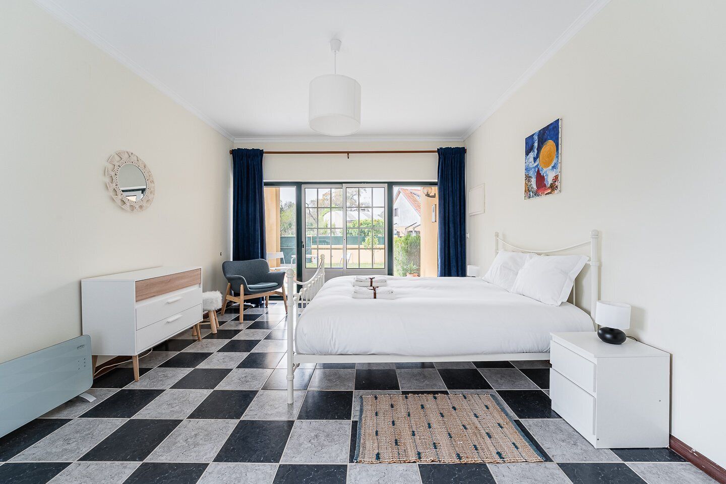 Camera d'albergo con un letto, una scrivania, una sedia, uno specchio e vista sull'esterno.