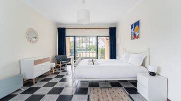 Camera d'albergo con un letto, una scrivania, una sedia, uno specchio e vista sull'esterno.