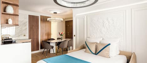 Ett modernt hotellrum med en stor säng, en matplats och ett kök.