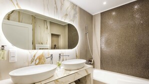 Ein modernes Badezimmer mit zwei Waschbecken, einem großen Spiegel und einer Duschkabine.