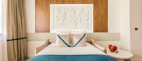 Una habitación de hotel con una cama, una mesita de noche, una ventana con cortinas y una obra de arte colgada en la pared.