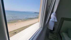 Une chambre avec une fenêtre donnant sur une plage.