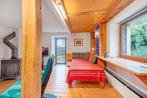 A room with a bed, a window, a wooden ceiling, and a radiator. - Apartment 'Ferienwohnung Karleidoskope' with Private Terrace, Private Garden and Wi-Fi (Buhlenberg)