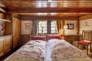 Une pièce en bois avec deux lits, un bureau et une chaise.