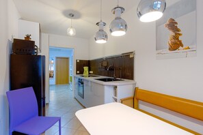 Una cocina moderna con refrigerador, lavamanos y comedor.
