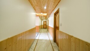 Passadís amb revestiment de fusta i sòl de marbre, que condueix a una porta al final.