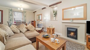 A living room with a fireplace, a sofa, a coffee table, and a television.
