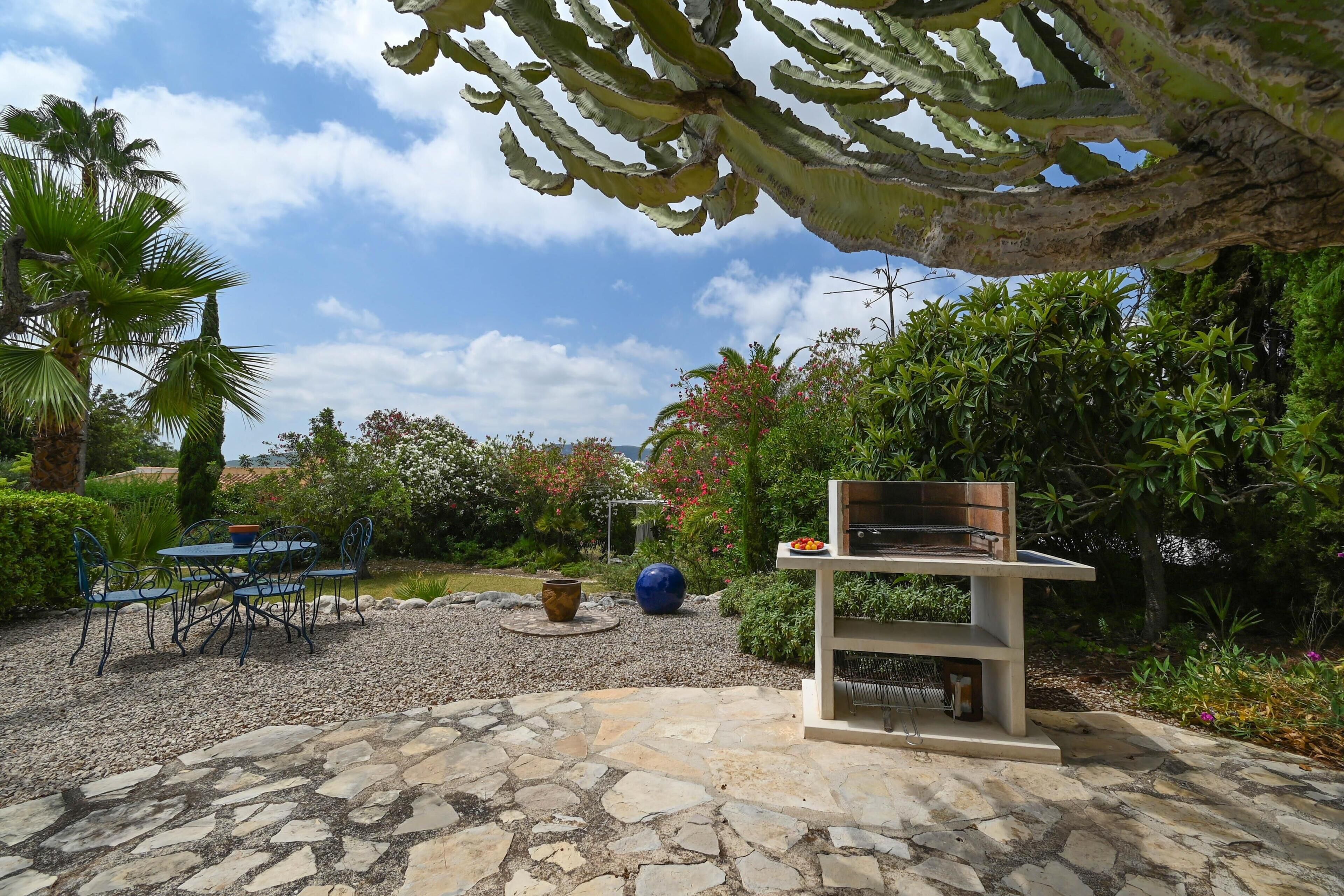 A patio with a grill, stone flooring, and outdoor furniture.
