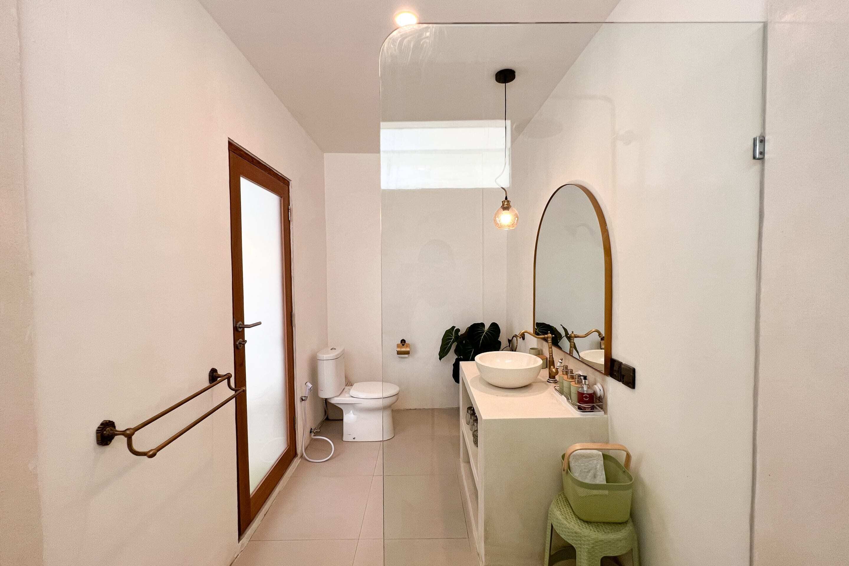 A modern bathroom with a toilet, sink, and mirror.
