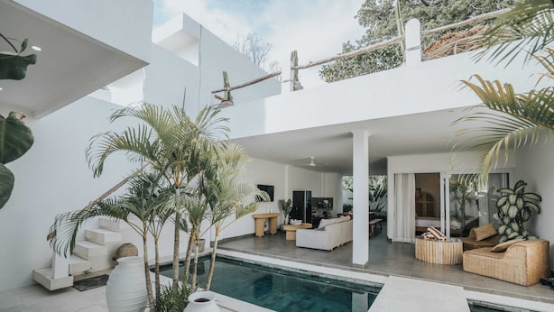 A modern house with a pool, outdoor seating, and a staircase leading to an upper level. - Villa Mood (Canggu)