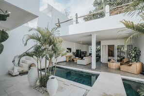 A modern house with a pool, outdoor seating, and a staircase leading to an upper level. - Villa Mood (Canggu)