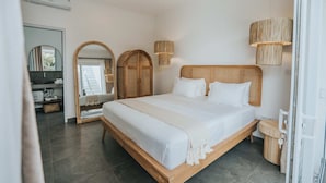 A modern bedroom with a large bed, wooden headboard, and a bedside table. - Villa Mood (Canggu)