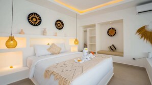 A modern bedroom with a large bed, bedside lamps, decorative wall art, and built-in shelving. - Villa Zahka (Munggu)