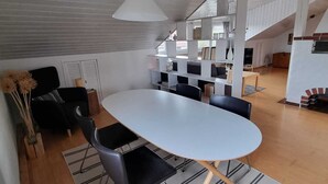 A modern kitchen with a large island, black chairs, and a hanging light fixture. - Gemütliche Dachgeschosswohnung bei Tutzing am Starnberger See (Tutzing)