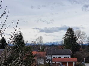 Un quartier résidentiel avec des maisons, une rue et des montagnes en arrière-plan.