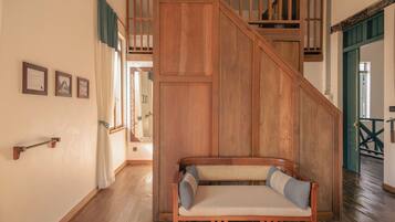 Una escalera de madera con un banco al pie.