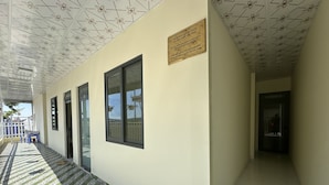 A corridor with a tiled floor, a ceiling with a geometric pattern, and a wall-mounted plaque. - OYO 1228 Gia Hoang Homestay (Xuan Huong - Da Lat)