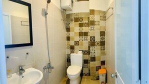 A bathroom with a sink, toilet, and shower. - talofofo hotel (Da Nang)