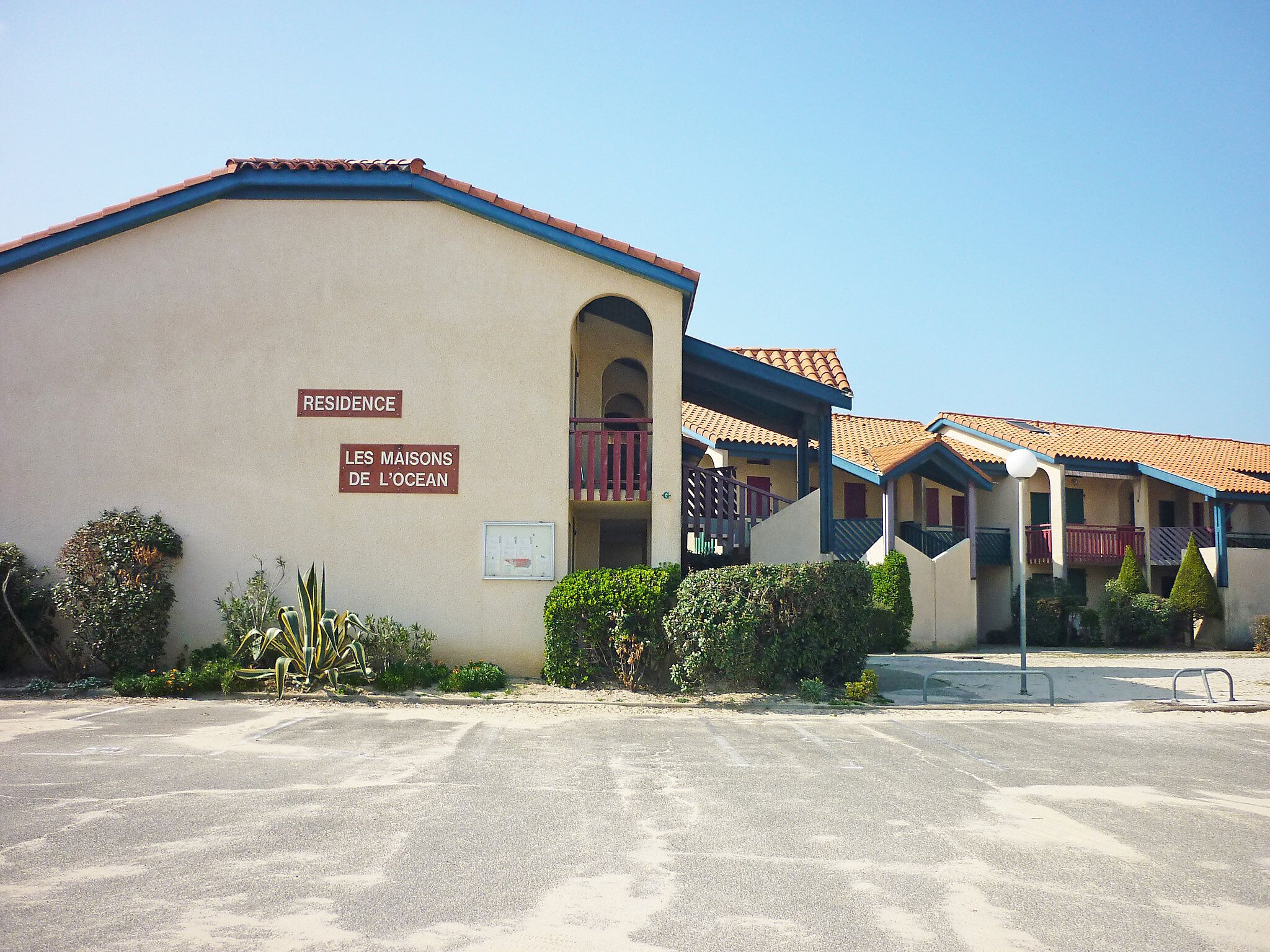 A building with a sign reading "RESIDENCE LES MAISONS DE L'OCEAN".