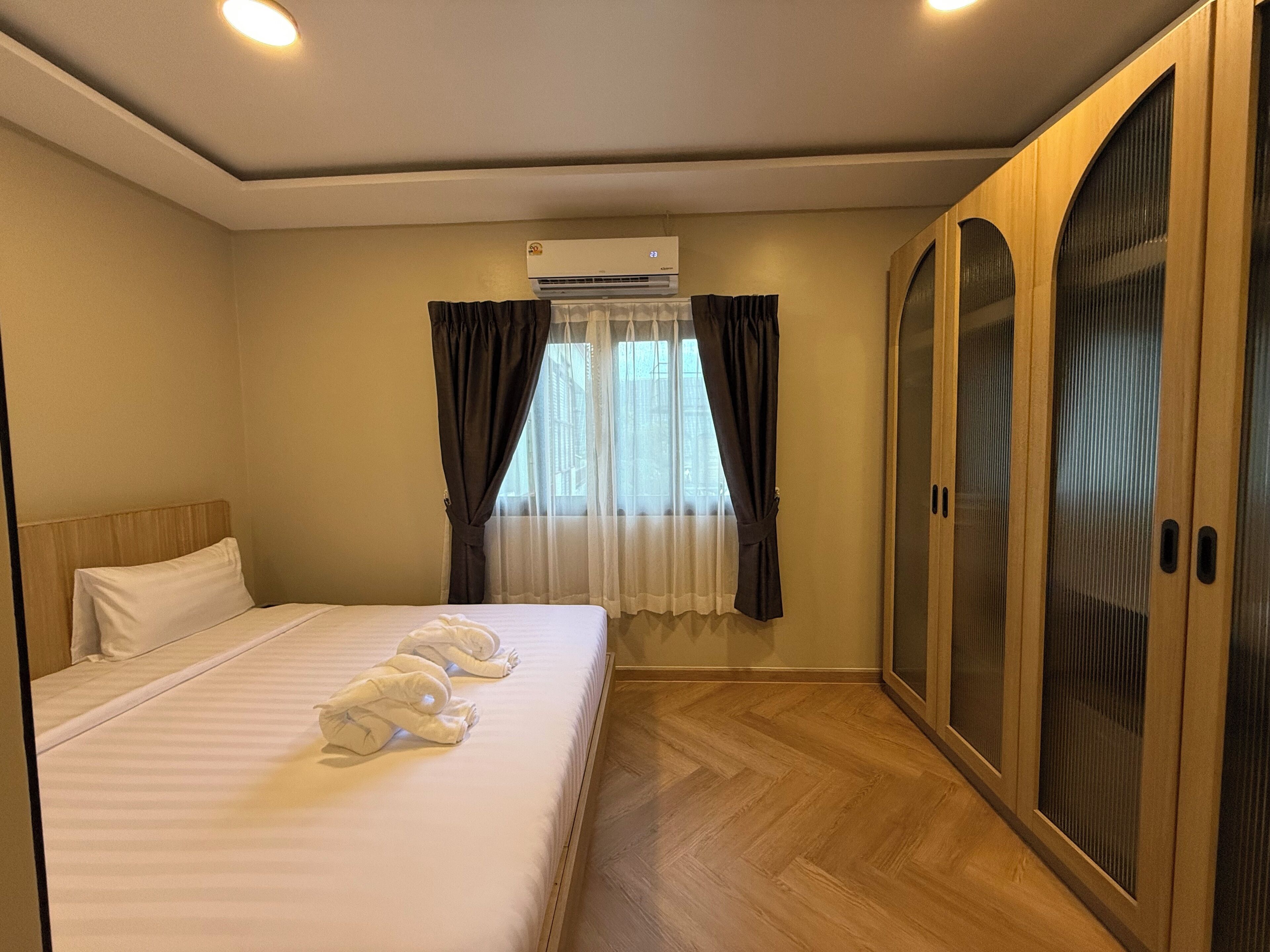 Quarto de hotel com cama, guarda-roupa e ar condicionado.