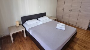 Quarto moderno com cama, mesa de cabeceira e guarda-roupa.
